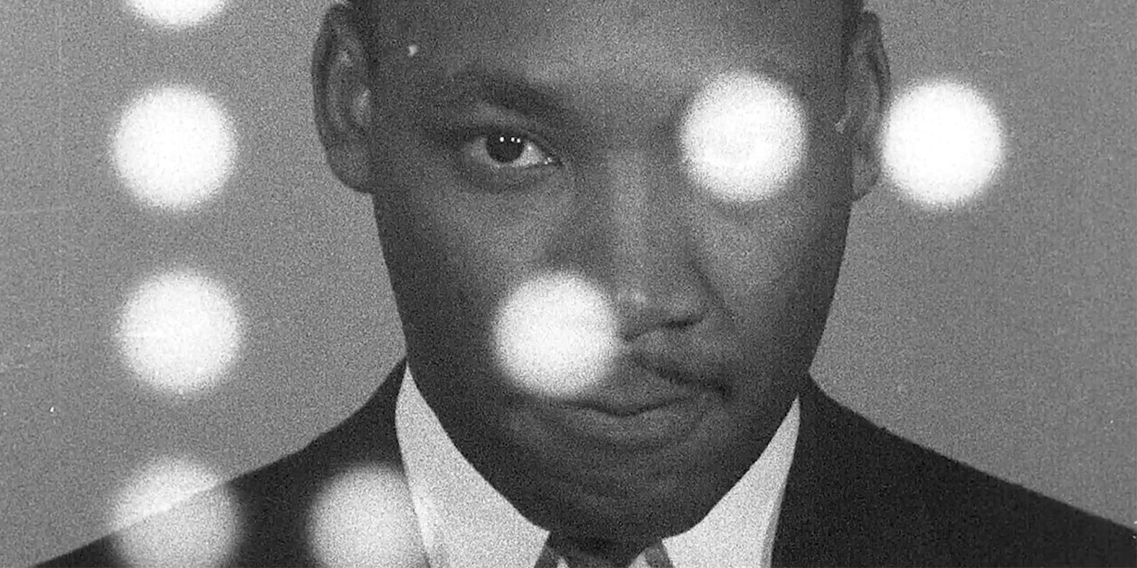 Black and white image of Martin Luther King, Jr. looking directly at the camera.